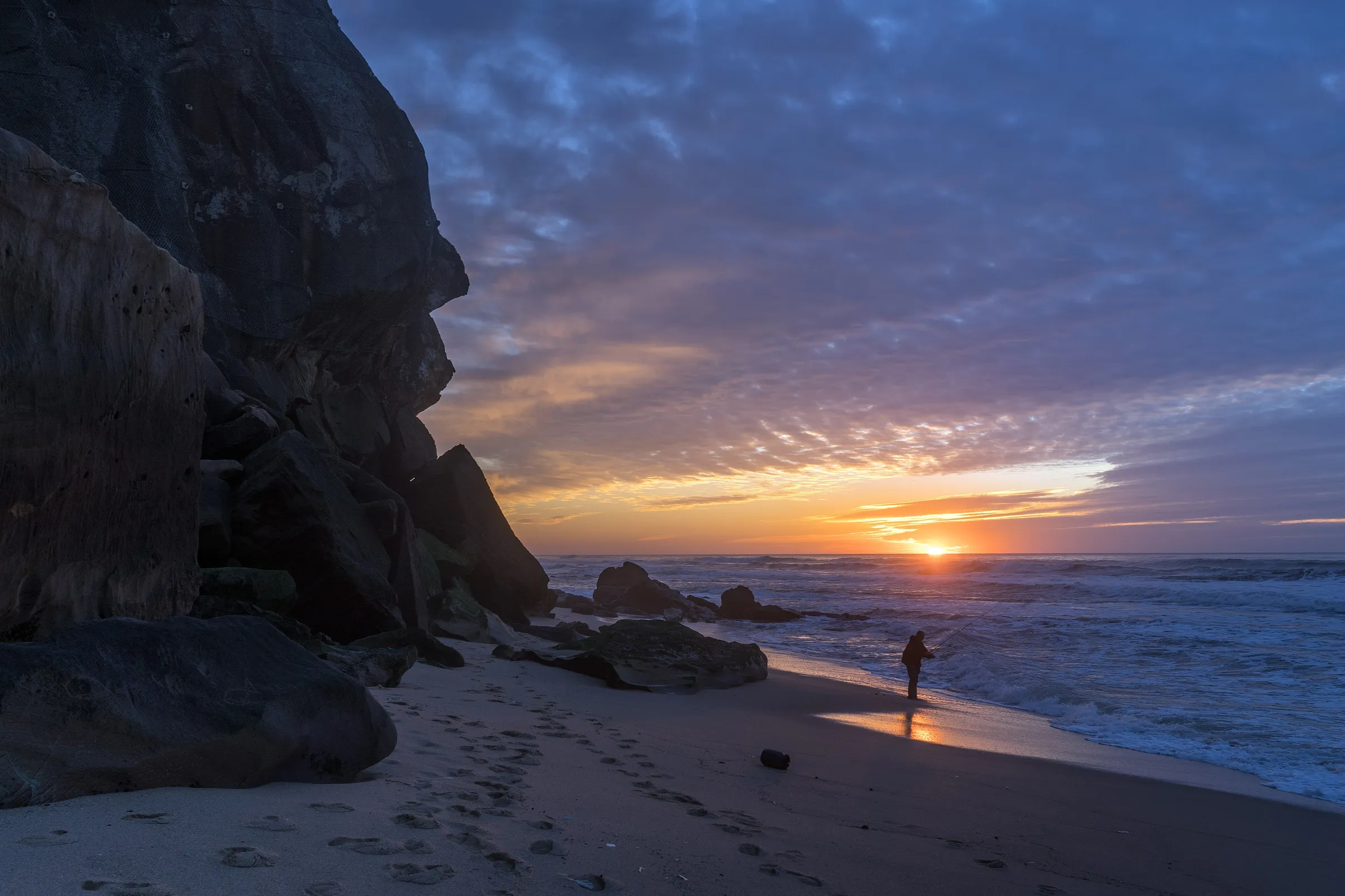 Pescador ao pôr do sol na Praia Formosa, em Santa Cruz